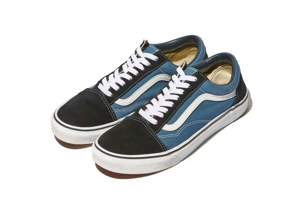 Blue and black low-sneakers with white laces, white side stripes, and white rubber soles