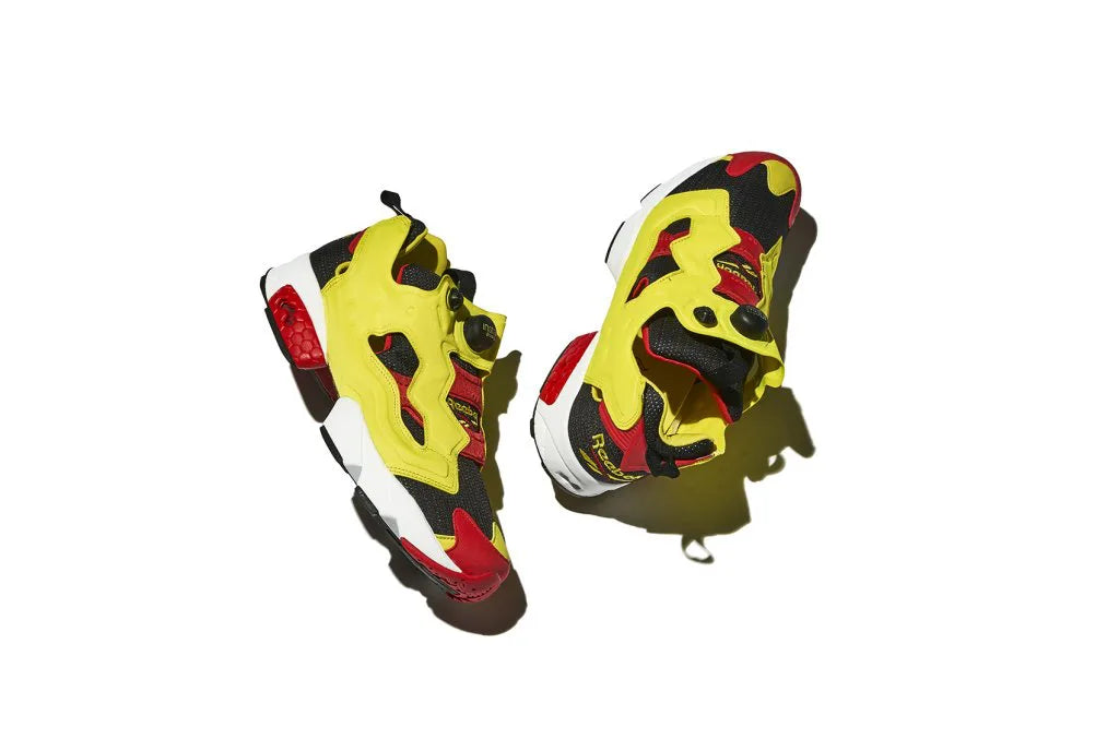 Pair of Reebok sneakers in bright yellow, red, and black