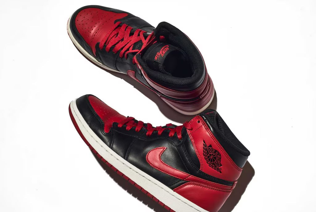 A pair of red and black high sneakers with red laces and a white sole