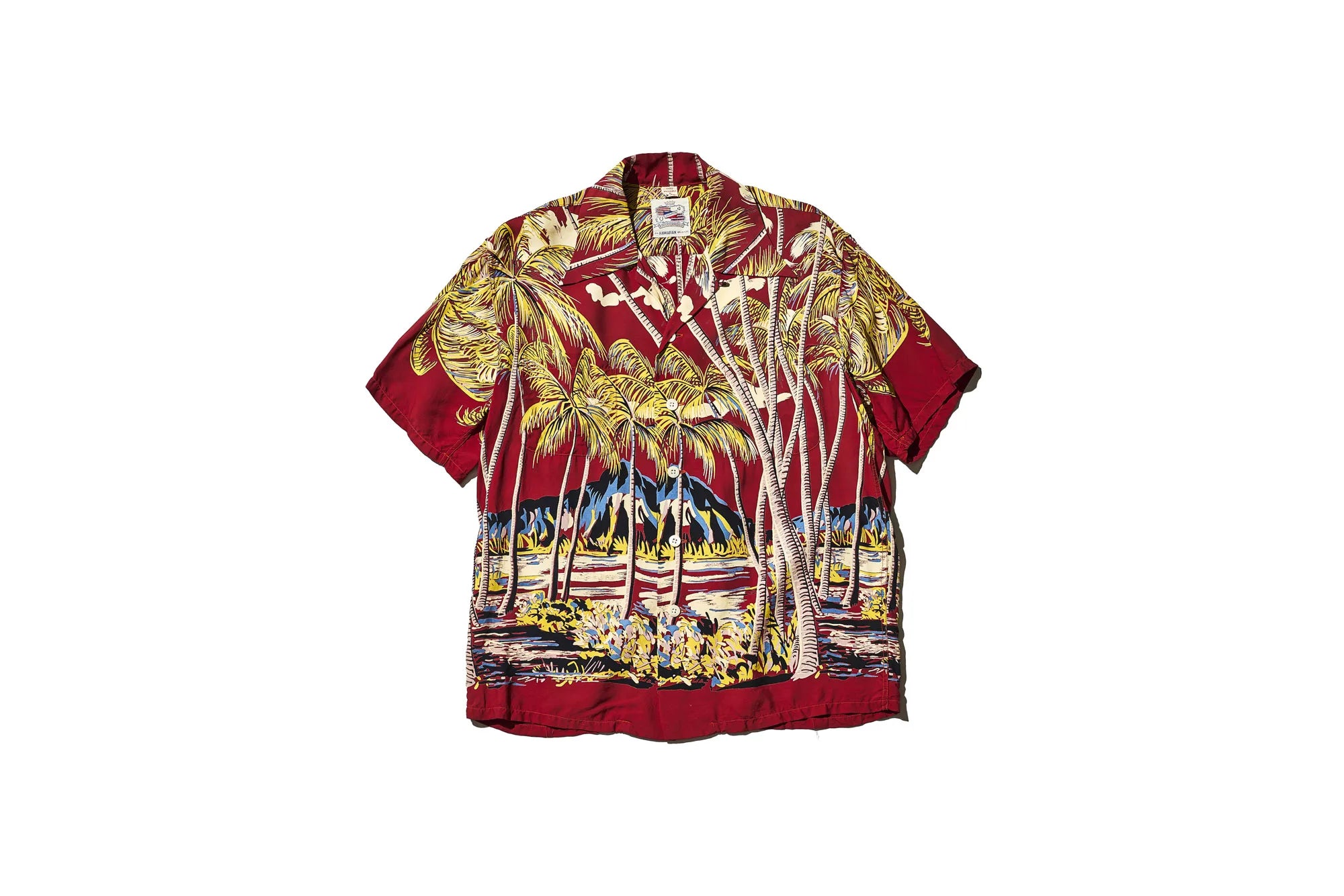 Red aloha shirt with palm trees mountains and a beach