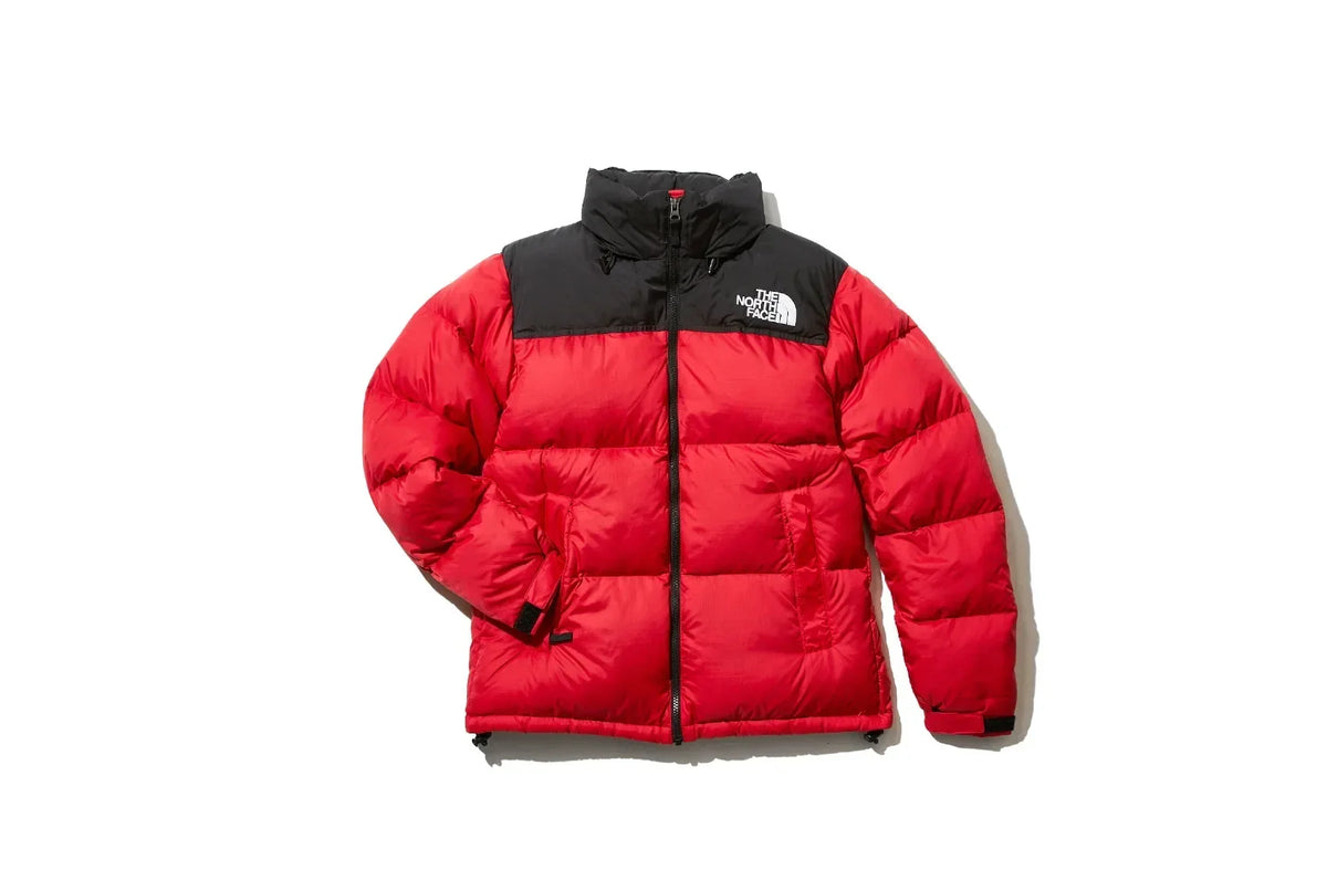 Red puffer jacket with a black material on the shoulder area with The North Face logo