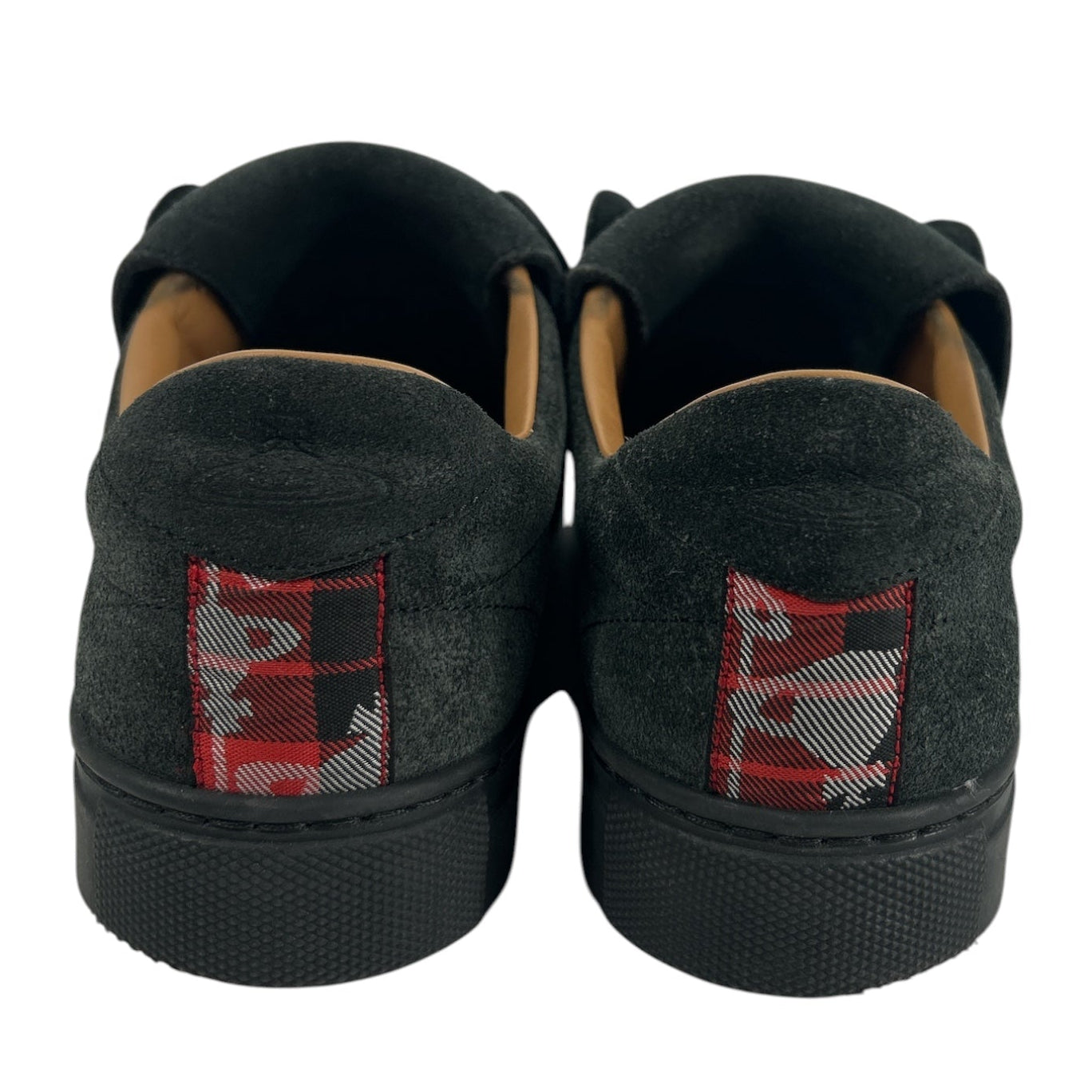 A pair of black slip-on sneakers shown from the back, featuring a textured black suede-like upper, black rubber soles, and a red and white graphic patch on the heel. view 3