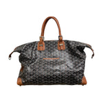 A brown GOYARD duffel bag with monogram pattern and leather trim.