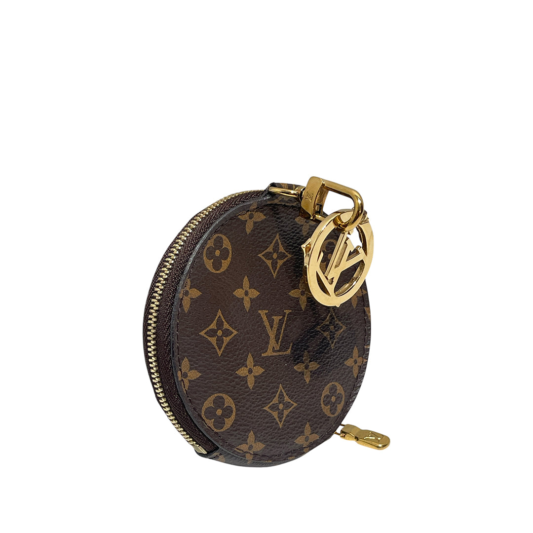Louis Vuitton monogrammed oval coin purse with gold-tone hardware and a prominent LV logo charm, shown on a plain white background.